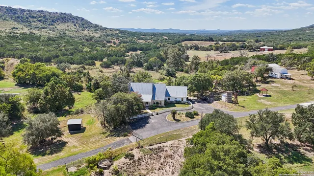 an aerial view of residential house with yard and mountain view in back