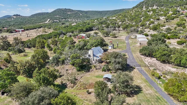 an aerial view of residential houses with outdoor space and trees