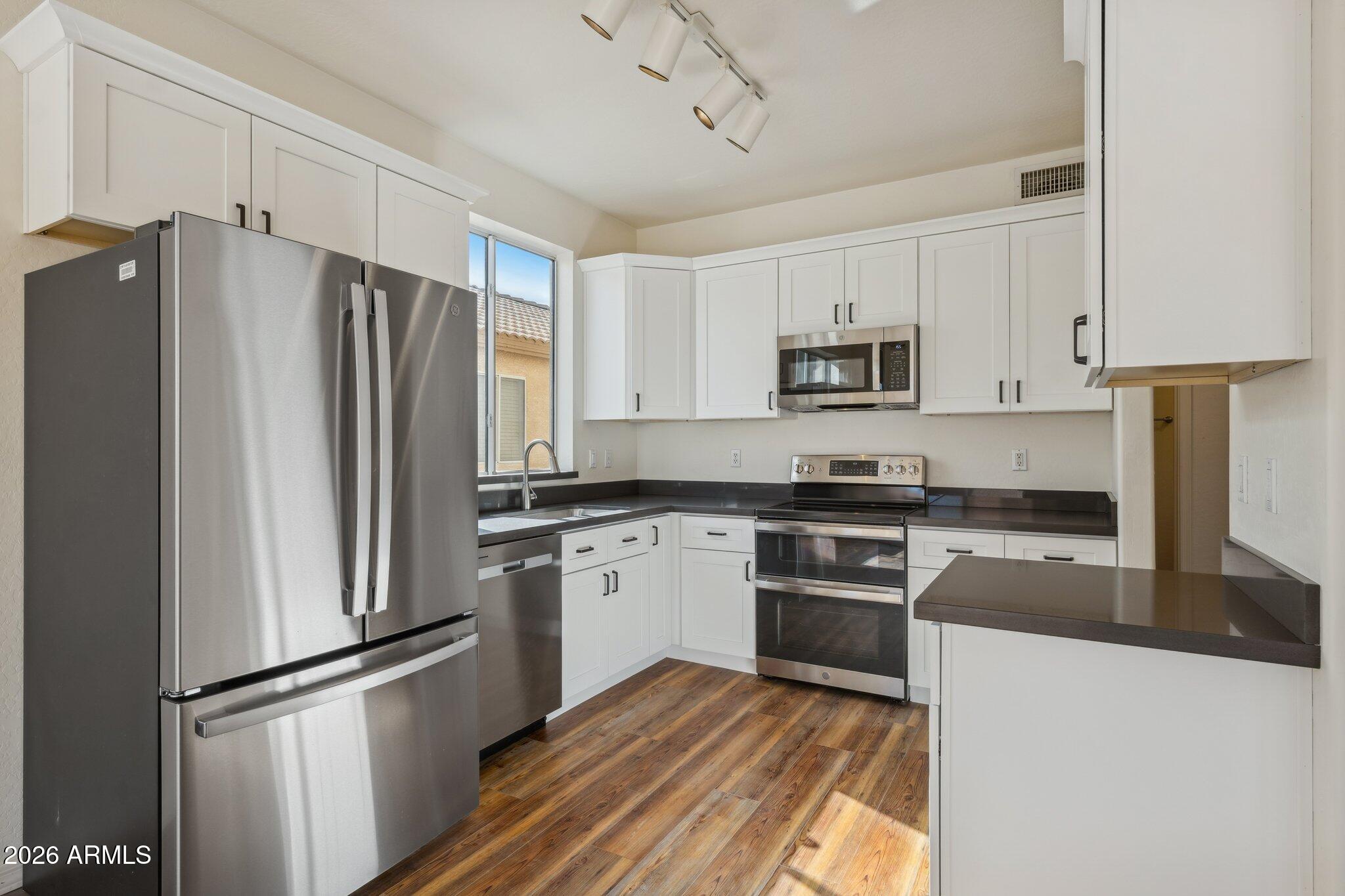 4034 East Chambers Street Phoenix, AZ 85040 - Photo 9 of 26 a kitchen with granite countertop a refrigerator stove and microwave