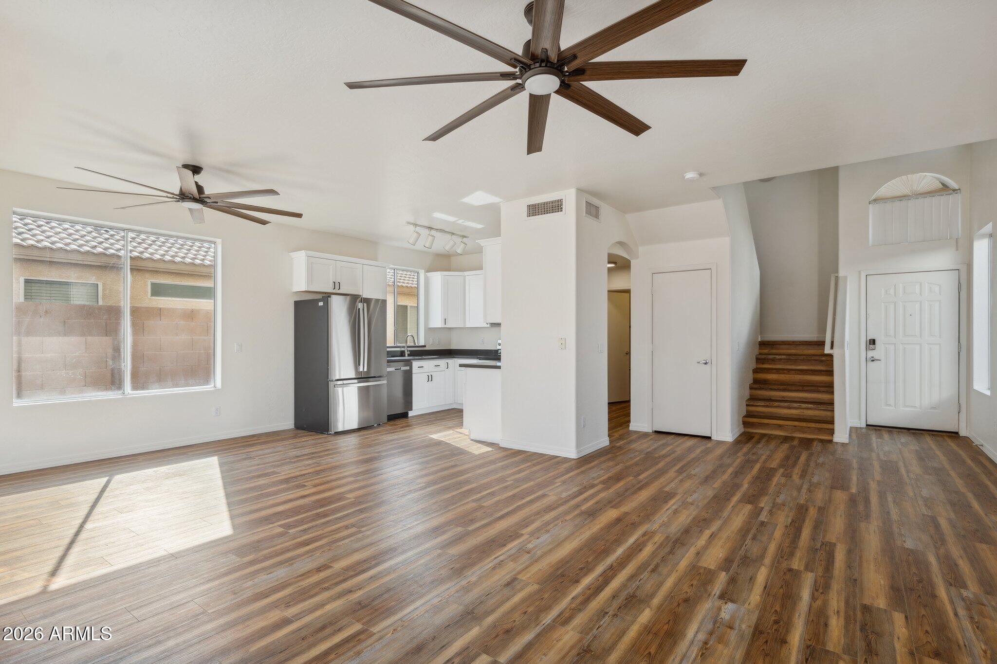 4034 East Chambers Street Phoenix, AZ 85040 - Photo 7 of 26 a view of a kitchen with wooden floor a ceiling fan and windows