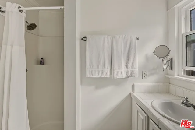a bathroom with a sink vanity granite toilet and shower