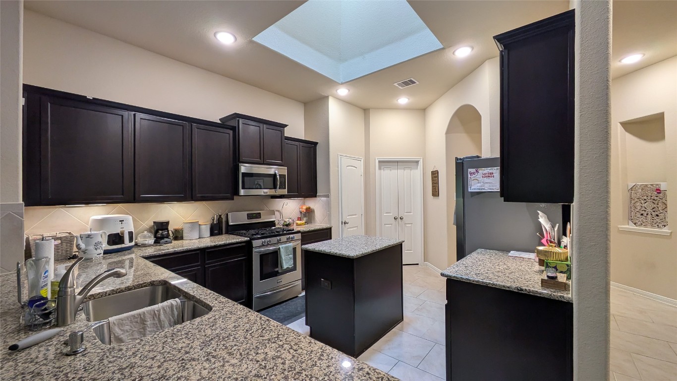 22330 Forbes Field Trail Spring, TX 77389 - Photo 4 of 8 a kitchen with stainless steel appliances kitchen island granite countertop a sink dishwasher stove and refrigerator with wooden cabinets