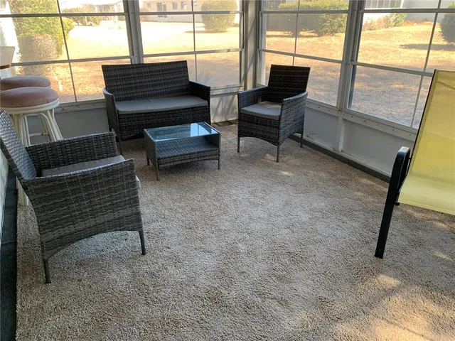 a living room with furniture and a floor to ceiling window