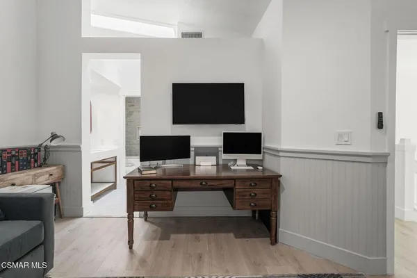a view of a workspace with furniture and a flat screen tv