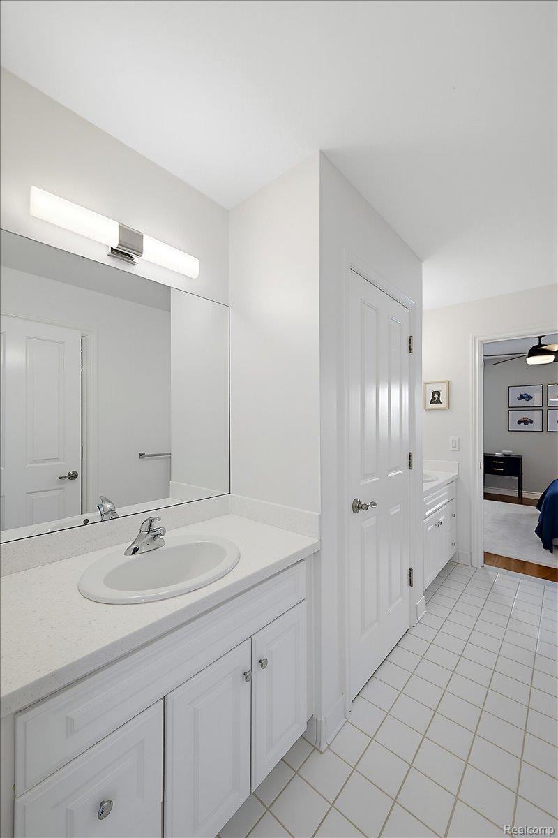 1422 Galena Rochester, MI 48306 - Photo 43 of 73 Vanity with an integrated sink, polished chrome faucet, and ample storage cabinetry, complemented by a large mirror and modern vanity lighting