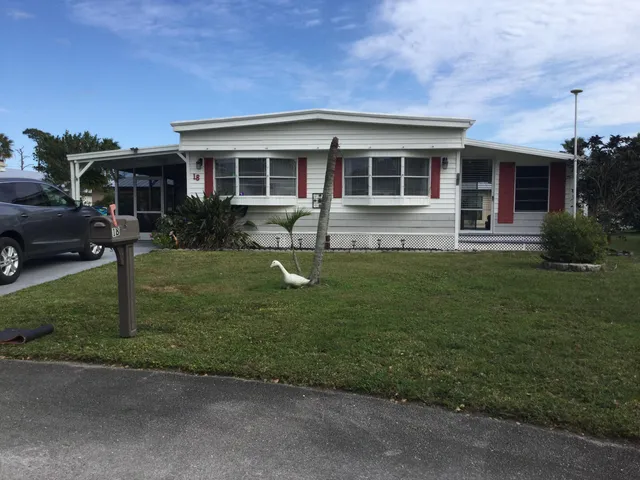 a front view of a house with a yard tree and wooden fence
