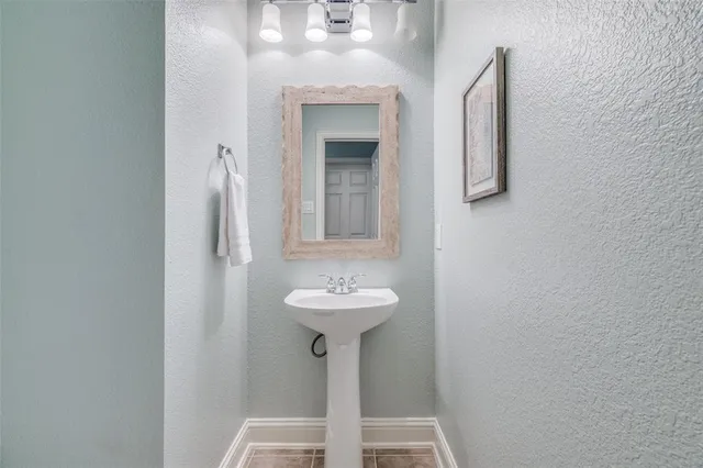 a kitchen with white cabinets and sink