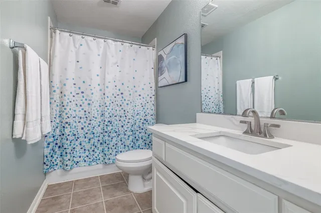 a bedroom with a large bed and a ceiling fan