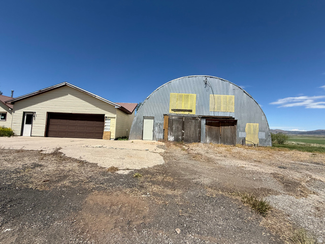 2002 Lund Road Bancroft, ID 83217 - Photo 3 of 28 Quonset hut structure featuring a corrugated metal exterior, large double wooden doors, and an additional single entry door