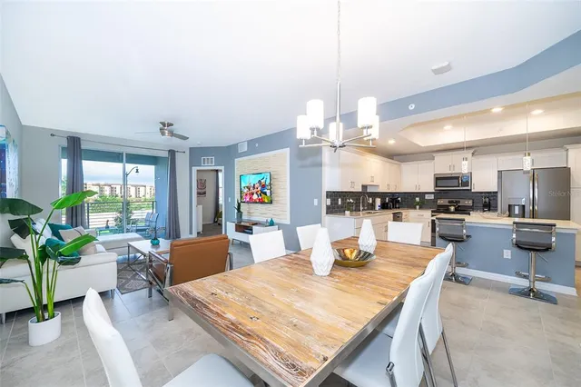 a dining room with wooden floor a chandelier a wooden table and chairs