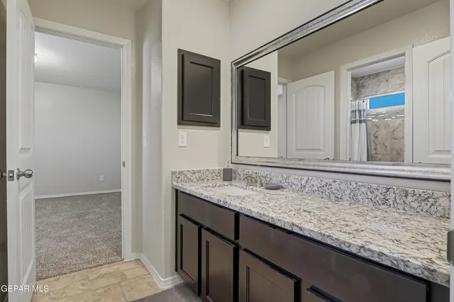 a bathroom with a granite countertop sink and mirror