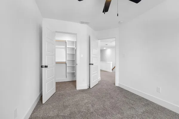 an empty room with an empty space and a ceiling fan