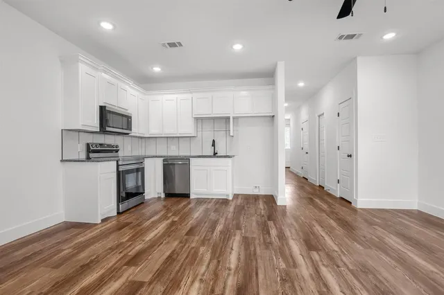 a kitchen with a refrigerator and a stove top oven