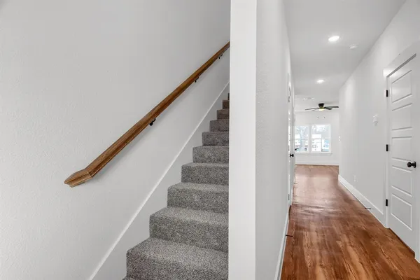 a view of a hallway with wooden floor and staircase