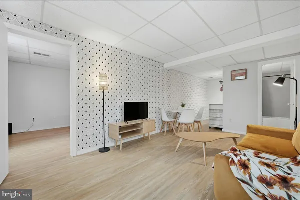 a living room with furniture a flat screen tv and a table