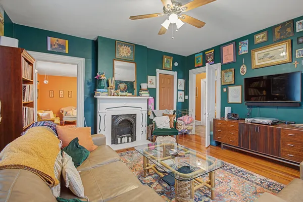 a living room with furniture a rug and a wall painting