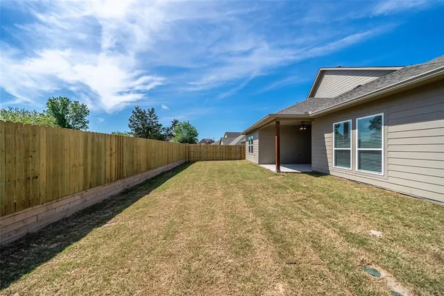 a view of backyard with small cabin and wooden fence