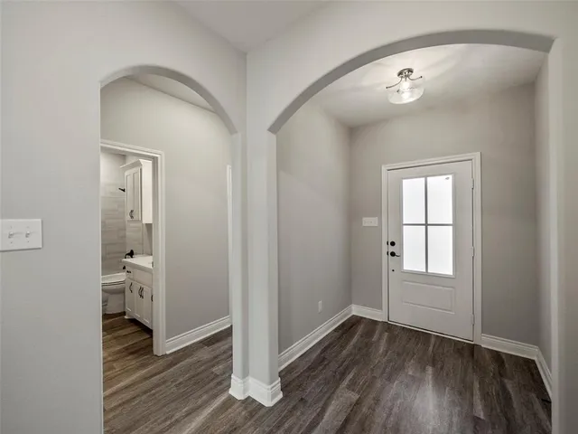 an empty room with wooden floor and a window