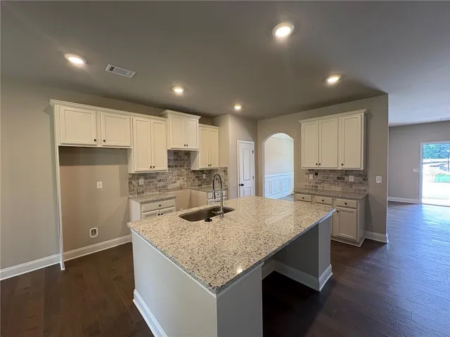 a kitchen with a center island appliances and cabinets