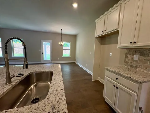 a kitchen with granite countertop a sink and a stove top oven