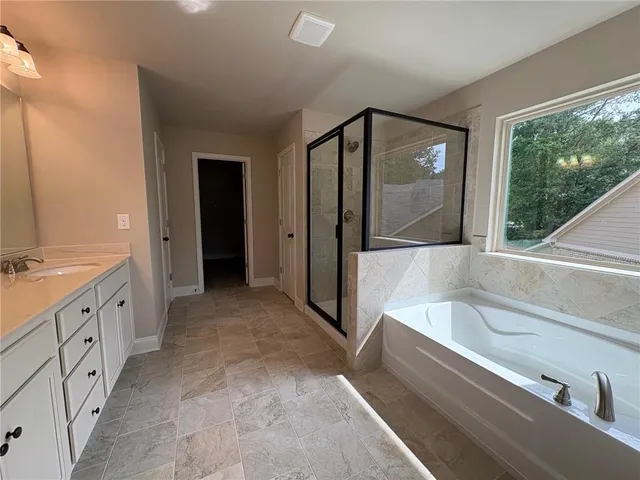 a spacious bathroom with a granite countertop tub sink and mirror