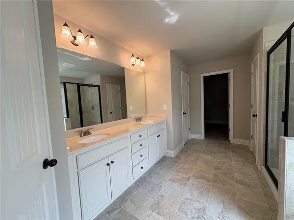 a spacious bathroom with a double vanity sink and mirror