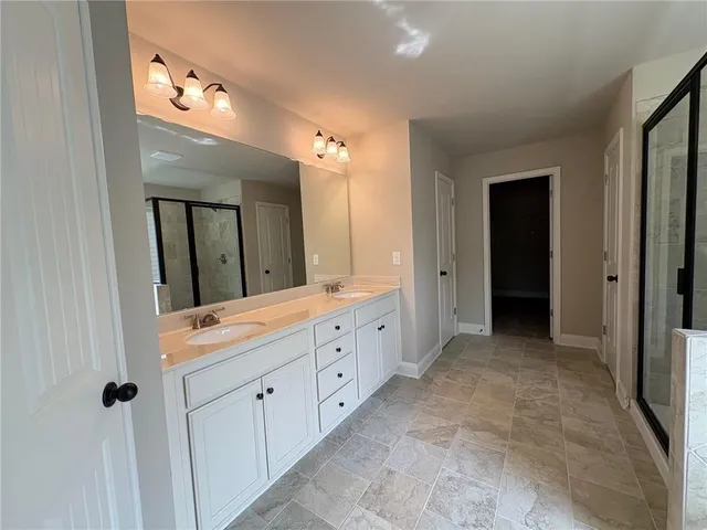 a spacious bathroom with a double vanity sink and mirror