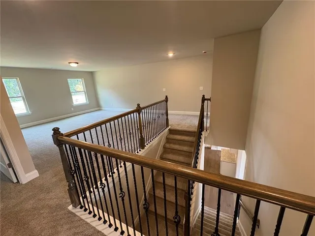 a view of staircase with railing and white walls