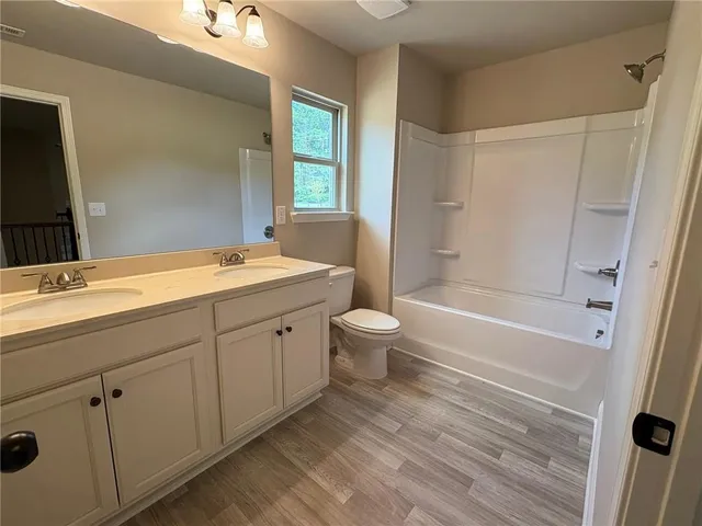 a spacious bathroom with a granite countertop sink a toilet and shower