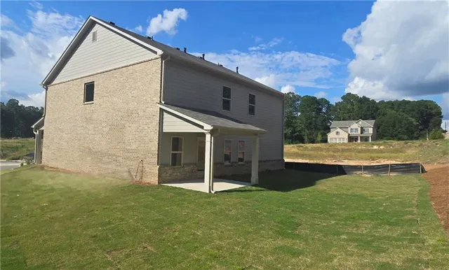 a view of a house with backyard and sitting area