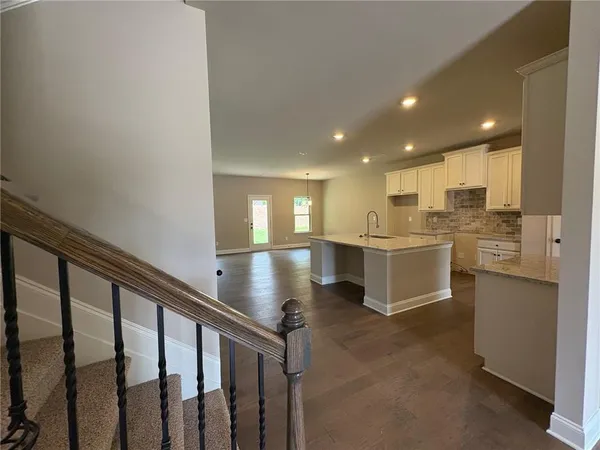 a open kitchen with white cabinets and white appliances