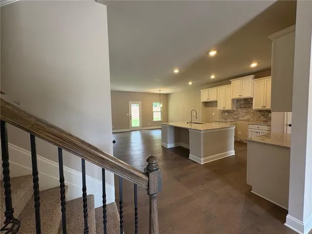 a open kitchen with white cabinets and white appliances