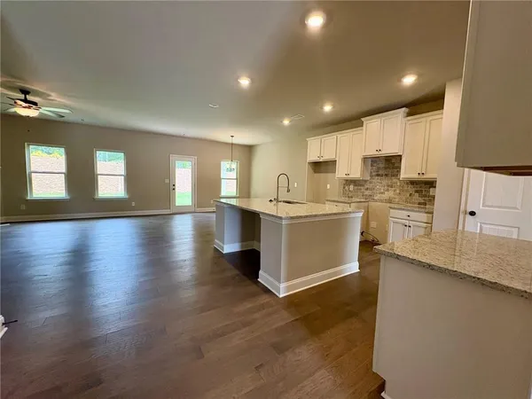a large white kitchen with lots of counter space a sink and appliances