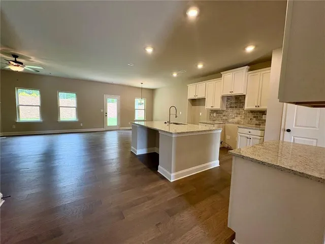a large white kitchen with lots of counter space a sink and appliances