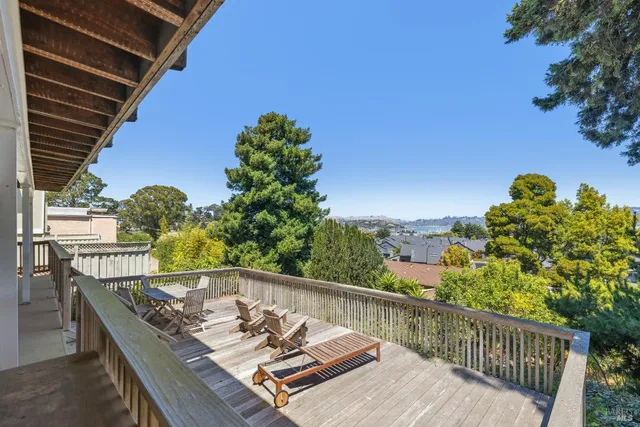 a balcony with wooden floor and outdoor seating
