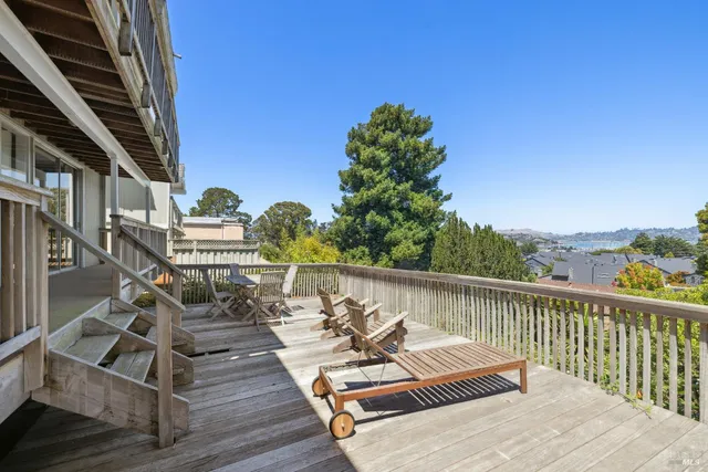 a view of a balcony with chairs and wooden floor