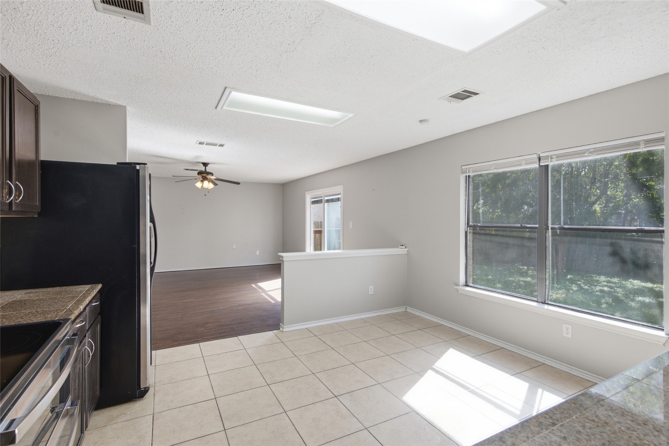 7900 Rosenberry Drive Austin, TX 78747 - Photo 9 of 27 A well-lit kitchen area with skylights, flowing into a spacious living area with outdoor access.