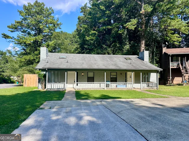 a front view of a house with a garden and trees