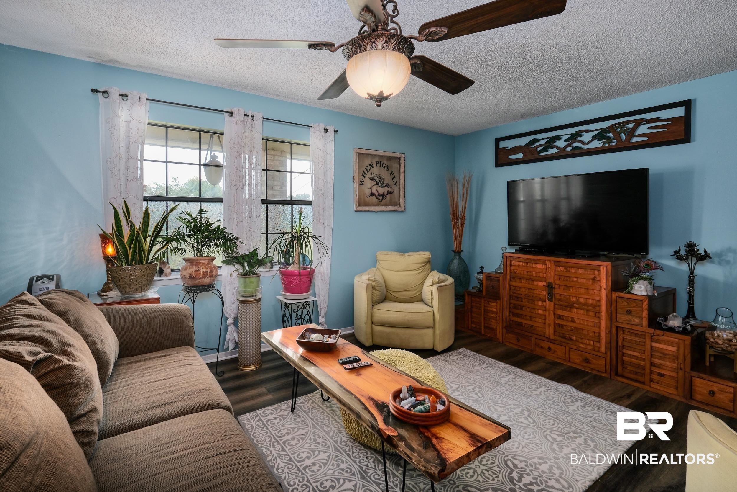504 Ariel Avenue Foley, AL 36535 - Photo 12 of 33 Living room with dark wood-type flooring, a textured ceiling, and ceiling fan