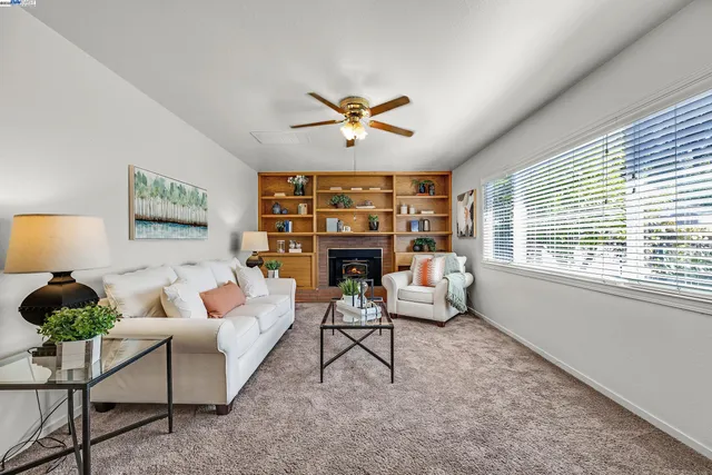 a living room with furniture a fireplace and a large window