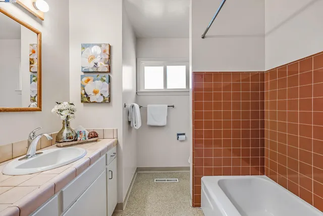 a bathroom with a granite countertop bathtub sink and mirror