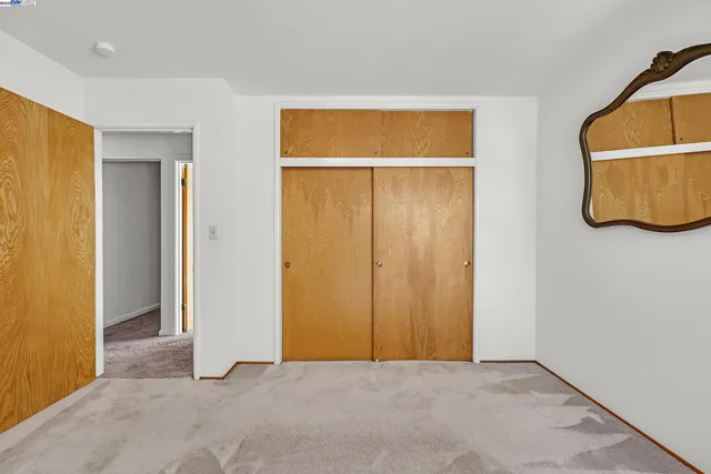 an empty room with closet and mirror