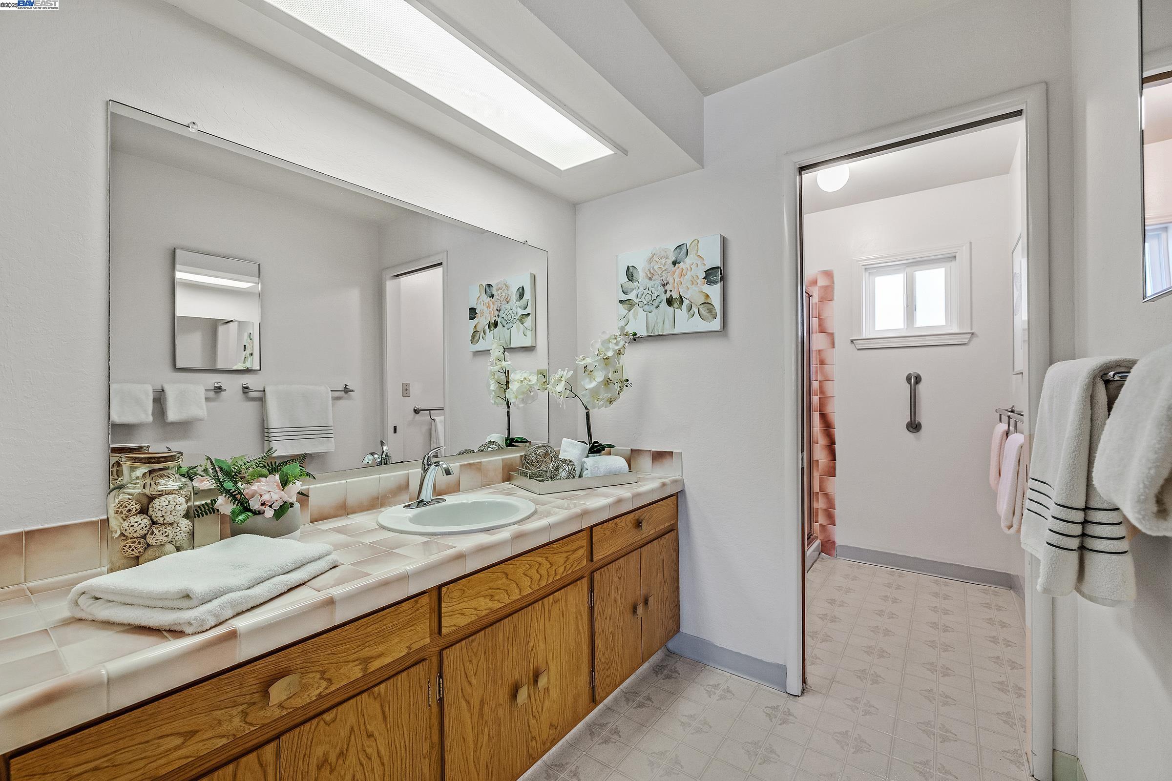 596 Tyler Avenue Livermore, CA 94550 - Photo 25 of 36 a spacious bathroom with a granite countertop sink and a mirror