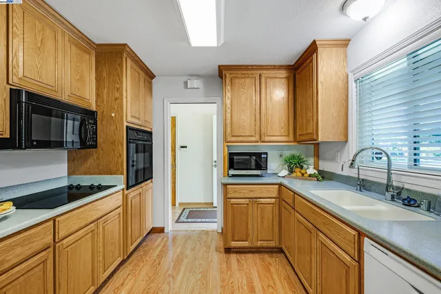 a kitchen with stainless steel appliances a sink cabinets and wooden floor