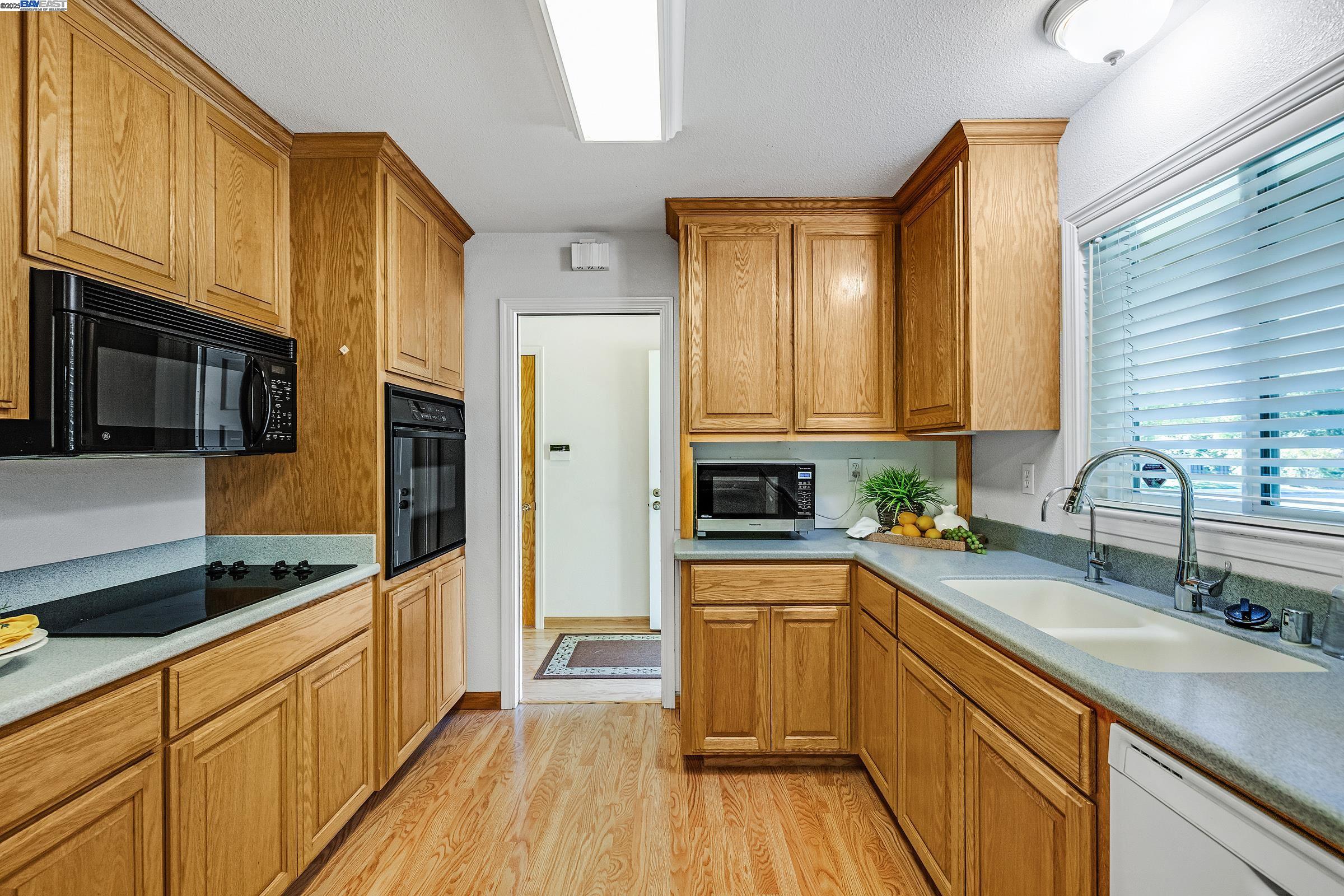 596 Tyler Avenue Livermore, CA 94550 - Photo 6 of 36 a kitchen with stainless steel appliances a sink cabinets and wooden floor