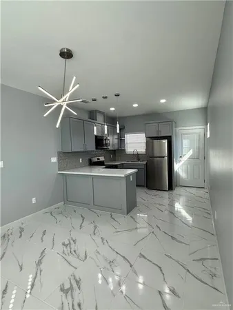 a kitchen with stainless steel appliances kitchen island sink refrigerator and cabinets