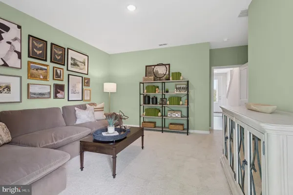 a living room with furniture and baby crib