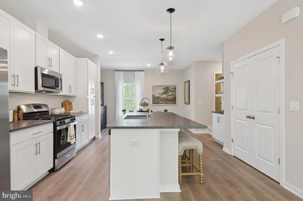 a large kitchen with stainless steel appliances kitchen island granite countertop a stove a sink and a refrigerator
