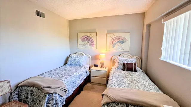 a bedroom with a bed and a dresser next to a window
