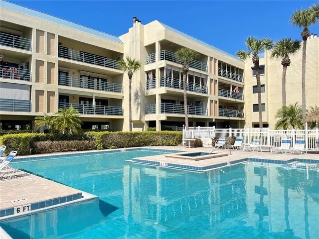 a front view of a residential apartment building with a yard table and chairs